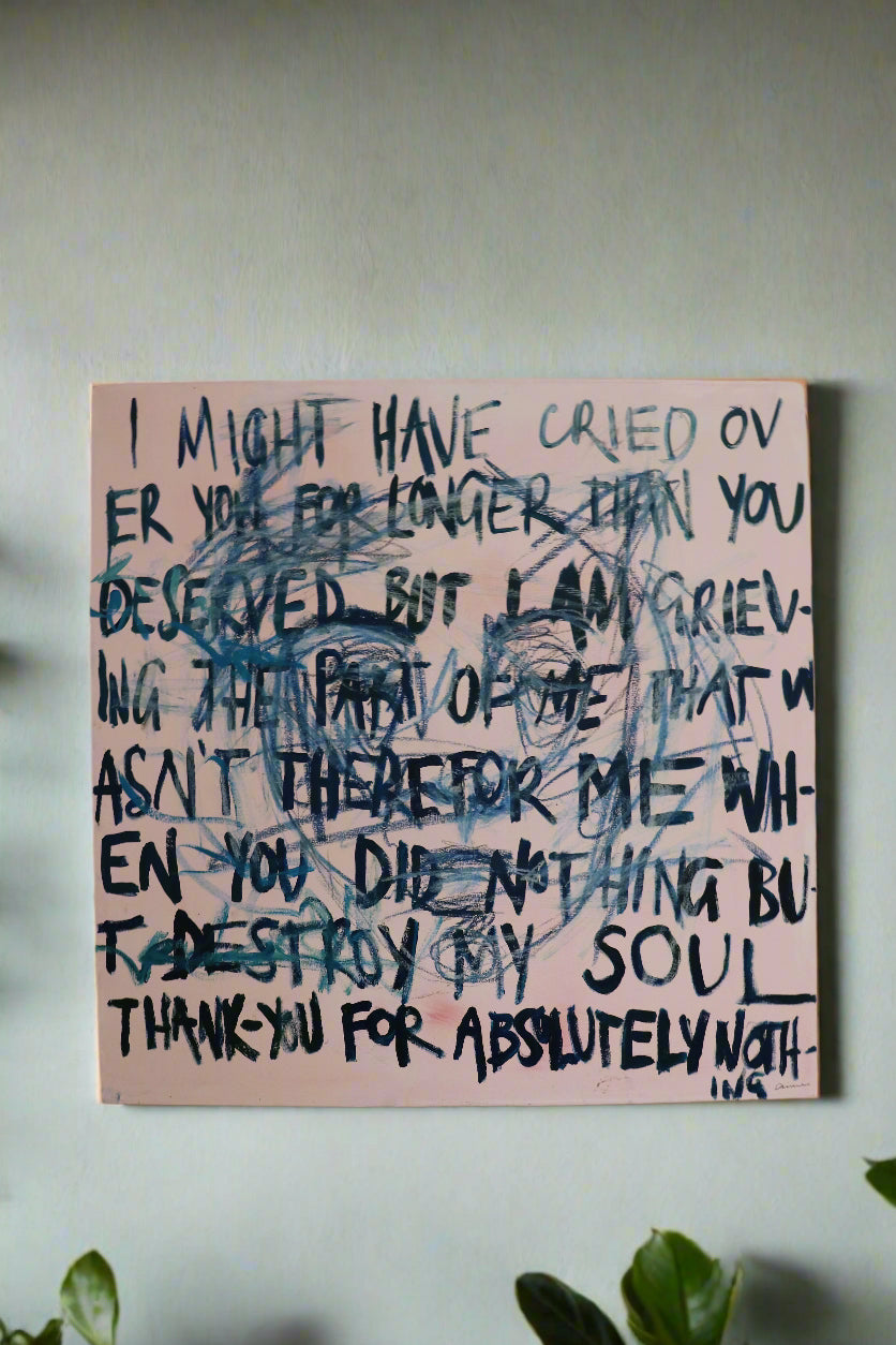 "I needed myself most" a square painting with blue text over it that reads "I might have cried over you for longer than you deserved but I am grieving the part of me that wasn't there for me when you did nothing but destroy my soul Thank you for absolutely nothing" with a pink back ground and an abstract face, hanging on a wall