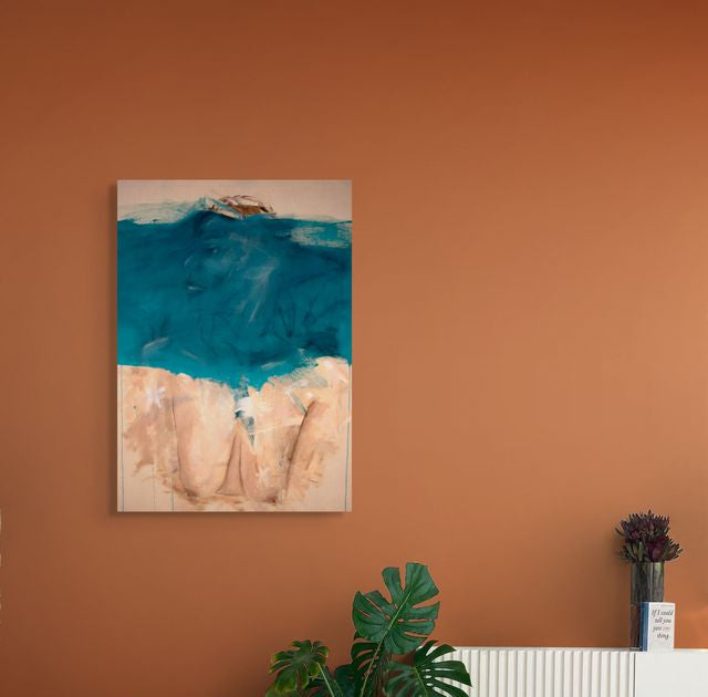 An Abstract portrait with the face covered in a blue stripe hanging on an orange wall creating a contrast between the blue/aqua colour in the painting
